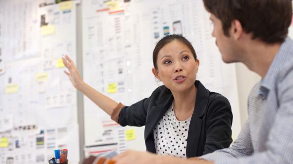 Two colleagues having a discussion in a meeting room.